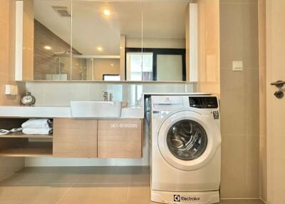 Modern bathroom with a large mirror and a washing machine