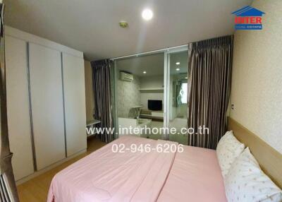 Cozy bedroom with pink bedspread, integrated closet, and glass sliding doors to adjoining room