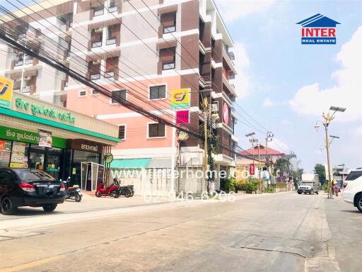 Street view with commercial building and neighboring apartments