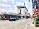 Street view of a building with various storefronts and vehicles