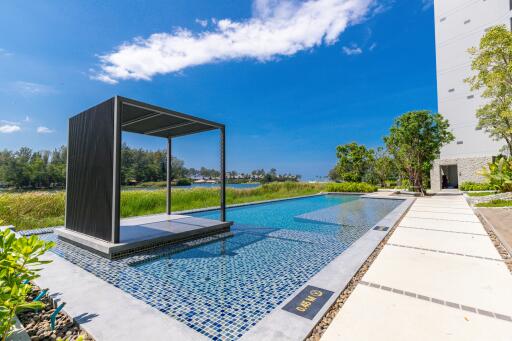 Outdoor swimming pool with shaded lounging area by the trees on a sunny day