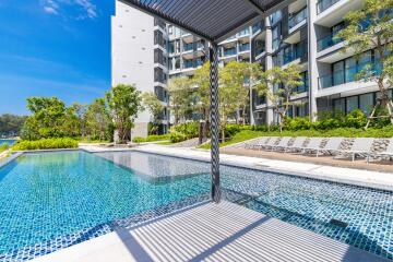 Outdoor swimming pool area with modern apartment building in the background