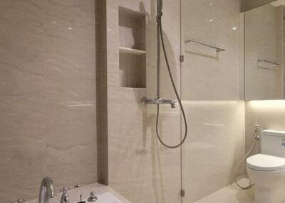 Modern bathroom with bathtub, shower, toilet, and tiled walls