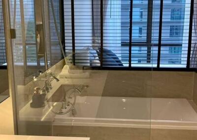 Modern bathroom with glass-enclosed bathtub