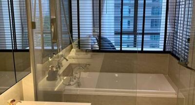 Modern bathroom with glass-enclosed bathtub