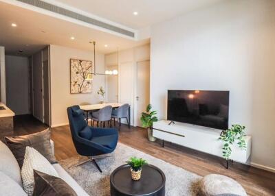 Modern living room with sofa, TV, and dining area