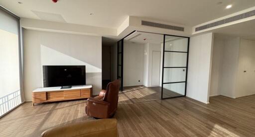 Modern living room with large windows, TV, and glass partitions