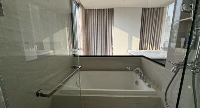 A modern bathroom with a bathtub and glass shower enclosure