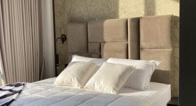 Modern bedroom with beige headboard and white pillows