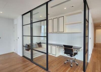 Modern home office with glass partition and hardwood floors