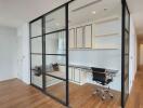 Modern home office with glass partition and hardwood floors