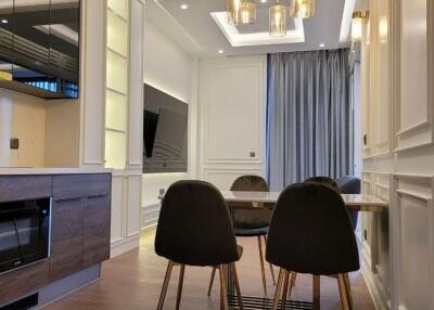 Modern dining area with a table and chairs, adjacent to a kitchen with built-in appliances