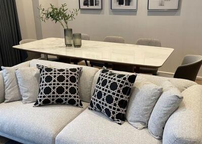 Modern living room with a gray sofa and a dining table