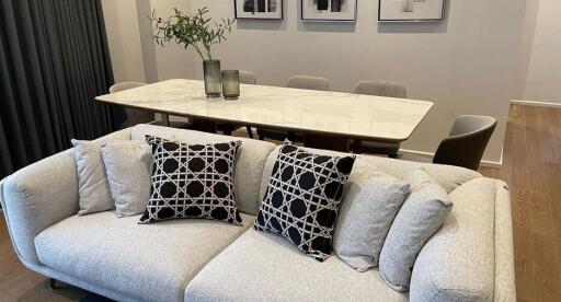 Modern living room with a gray sofa and a dining table