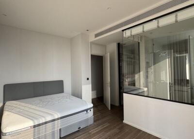 Modern bedroom with large window and glass-enclosed bathroom