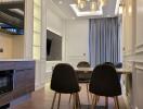 Modern dining area with black chairs, wooden table, and large wall-mounted TV.