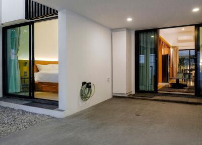 Modern house with illuminated bedroom and living room visible through sliding glass doors