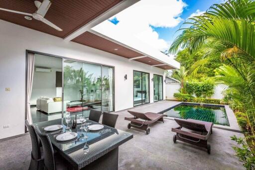 Modern outdoor patio area with pool and dining set