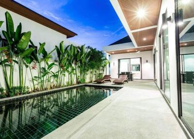 A luxury villa with a private swimming pool and modern outdoor lounge.