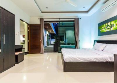 Modern bedroom with large bed, wardrobe, desk, and access to outdoor area