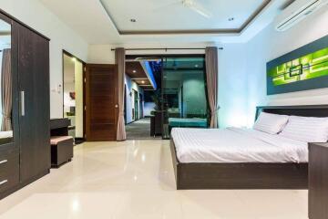 Modern bedroom with large bed, wardrobe, desk, and access to outdoor area