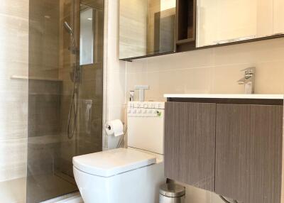 modern bathroom with glass shower, sink, and toilet