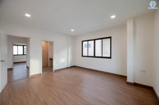 Spacious empty bedroom with wooden flooring and large windows