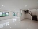 Spacious and modern main living area with staircase and large windows