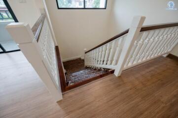 Staircase with wooden floors and white balustrades