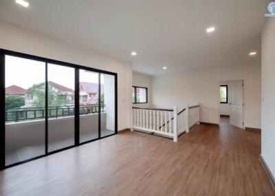 Spacious main living area with large sliding glass doors, balcony access, wooden flooring, and bright natural lighting.