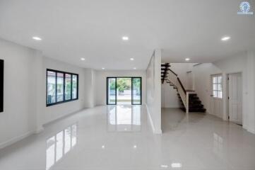 Spacious living room with large windows and staircase