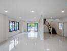 Spacious living room with large windows and staircase