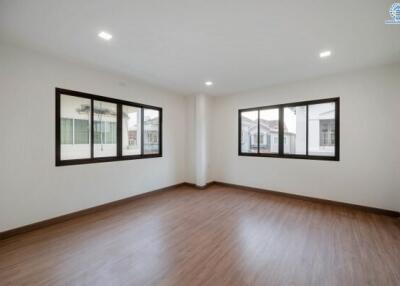 Spacious empty bedroom with wooden floor and large windows