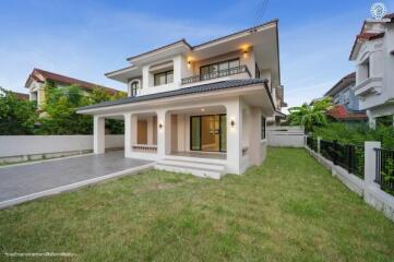 Front view of a modern two-story house with large lawn and patio