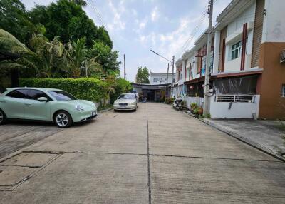 Driveway with parked cars in front of residential buildings