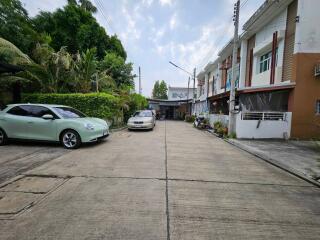 Driveway with parked cars in front of residential buildings