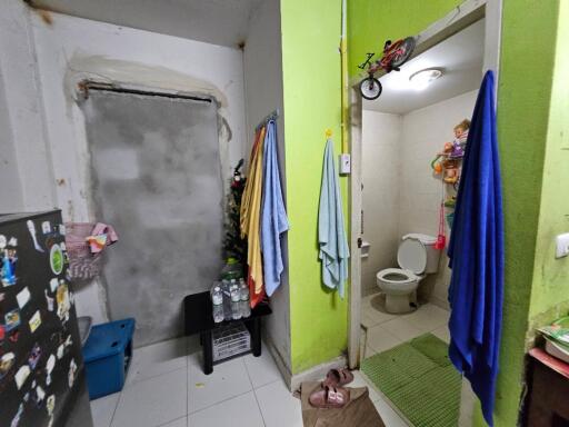 Entrance to bathroom in an apartment showing towels and a small hallway