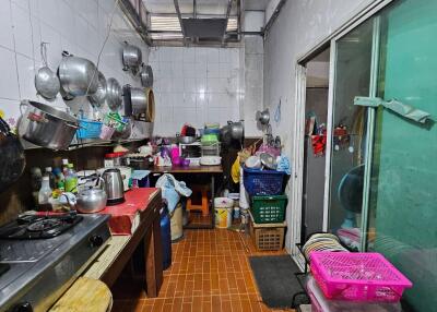 Crowded kitchen with various utensils and appliances