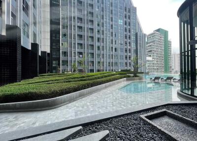 Outdoor pool area with modern apartment buildings in the background