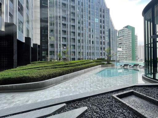 Outdoor pool area with modern apartment buildings in the background