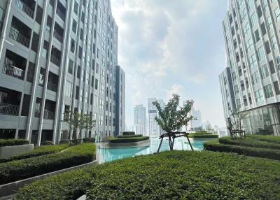View of high-rise buildings surrounding a central pool area with greenery