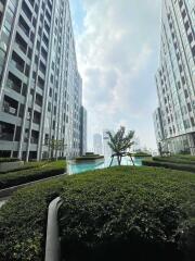 View of high-rise buildings surrounding a central pool area with greenery