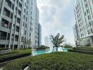 View of high-rise buildings surrounding a central pool area with greenery