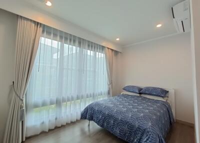 Modern bedroom with large window and blue bedding