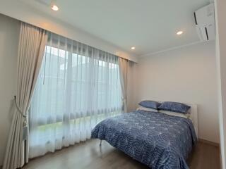 Modern bedroom with large window and blue bedding