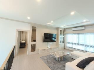 Modern living room with large TV and natural lighting