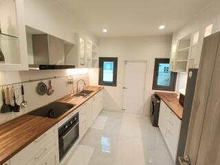 Modern kitchen with wooden countertops and white cabinets