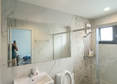 Modern bathroom with glass shower enclosure and wall-mounted sink