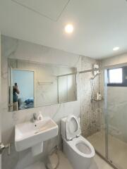 Modern bathroom with glass shower enclosure and wall-mounted sink