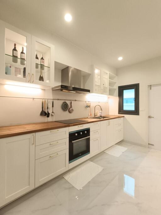 Modern kitchen with white cabinetry and wooden countertops